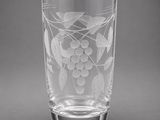 a glass with a design of grapes and leaves on it