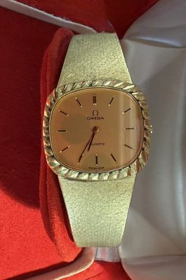 an image of a gold watch on a red cloth