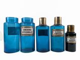 several bottles of different sizes and colors are lined up on a white surface