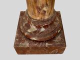 a marble pedestal with a vase on top of it