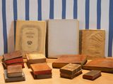 many old books sitting on a table next to each other