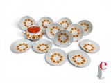 many plates with orange flowers on them on a white surface