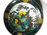une assiette décorative ornée d'un oiseau et de fleurs