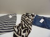 trois vêtements posés sur une table blanche à côté d'un jean
