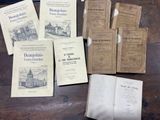 several old books are sitting on a wooden table next to an open book