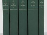 quatre livres verts empilés les uns sur les autres sur une table