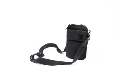 le petit sac noir est muni d'une bandoulière et est attaché à un cordon