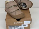 des chaussures de petit garçon dans une boîte posée sur une surface blanche