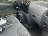 the interior of a small car with a laptop on the dashboard