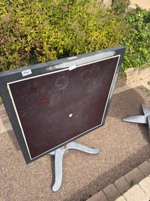 a broken television sitting on the sidewalk next to a bush