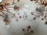 a plate with a design of flowers and leaves on it