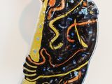 a glass sculpture of a woman standing on a wooden table