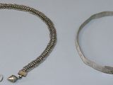 deux bracelets en argent et un bracelet en argent posés sur une surface blanche