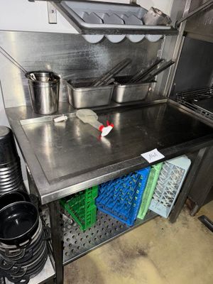 a stainless steel counter top with pots and pans on it