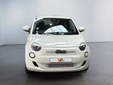 white small car parked in a large room with a white wall