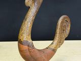 wooden sculpture of a bird on a wooden stand on a table