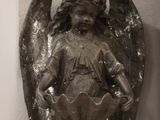 a statue of an angel on the wall next to a clock