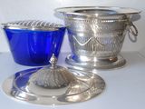 a blue glass bowl and a silver plate on a table
