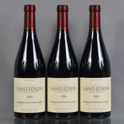 three bottles of wine sit on a table in front of a gray background