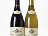 two bottles of wine sitting next to each other on a white surface