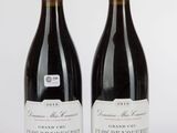 deux bouteilles de vin rouge posées l'une à côté de l'autre sur une table
