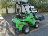 a small green tractor parked in a parking lot