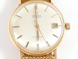 an image of a gold wrist watch with a white dial