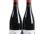two bottles of red wine sitting next to each other on a white surface