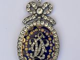 un gros plan d'un pendentif bleu et or orné de diamants