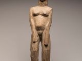 a wooden statue of a man with a hat on his head
