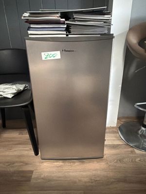 a silver refrigerator sitting in the corner of a room