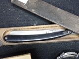 a knife and a watch in a box on a table