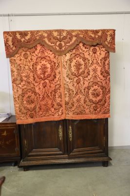 a very tall cabinet with a curtain on top of it
