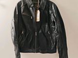 black leather jacket hanging on a hanger on a wall