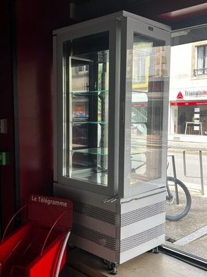 une chaise rouge placée devant une vitrine en verre