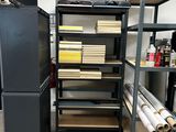 a refrigerator and some shelves in a room with many rolls of paper