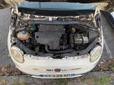 a small car with its hood open on the side of the road