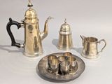 un plateau en argent sur lequel sont posés une théière et des tasses en argent
