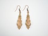 a pair of gold tone earrings with crystals on a white background