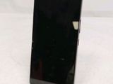 the back of a black cell phone sitting on top of a white table
