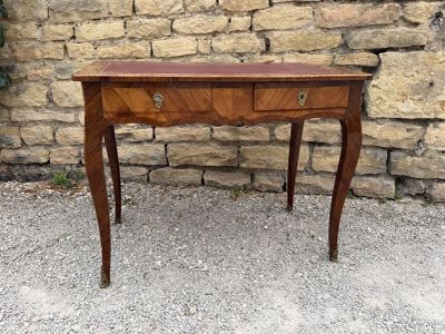 a small table with a drawer on it in front of a stone wall