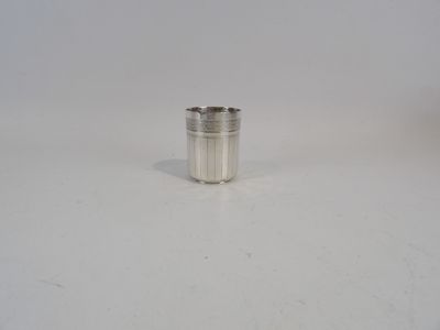 une coupe en argent posée sur une surface blanche, sur fond blanc