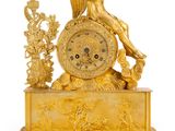 une image représentant une horloge en or sur laquelle se trouve une femme