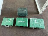 three green boxes sitting next to each other on the floor