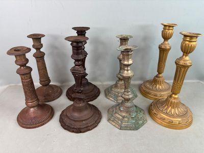de nombreux types différents de bougeoirs posés sur une table