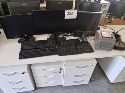 trois écrans d'ordinateur et un clavier posés sur un bureau