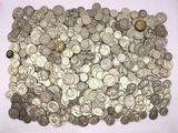 a pile of silver coins sitting on a white surface