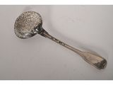 une cuillère ancienne en argent posée sur une surface blanche, avec un manche en argent