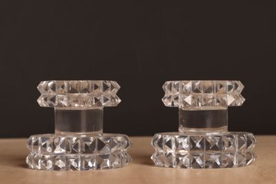 une paire de bougeoirs en verre transparent posés sur une table en bois