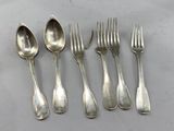 six forks and spoons are lined up on a table